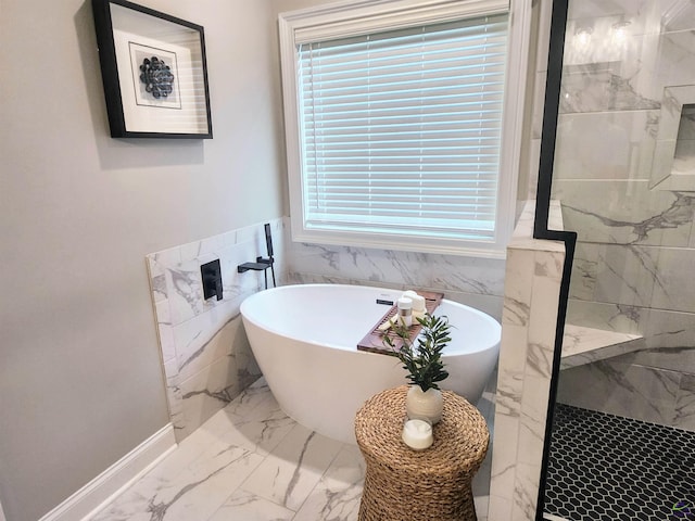 109 Raspberry Trl, Perry, GA 31069 - bathroom with marble look tiles, tile walls, a freestanding bath, healthy amount of natural light, and a marble finish shower
