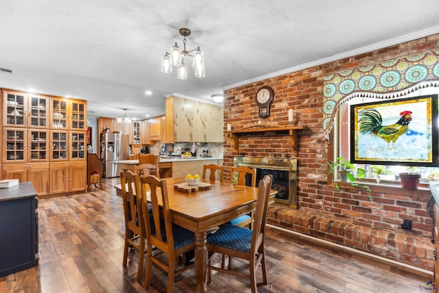 113 Chestnut Rd, Warner Robins, GA 31088 - dining area featuring a chandelier, ornamental molding, a textured ceiling, wood finished floors, and a fireplace