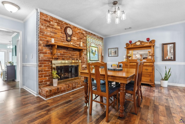 113 Chestnut Rd, Warner Robins, GA 31088 - dining area with a textured ceiling, hardwood / wood-style flooring, ornamental molding, a brick fireplace, and a chandelier