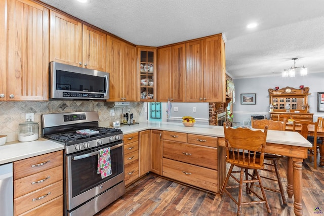 113 Chestnut Rd, Warner Robins, GA 31088 - kitchen with appliances with stainless steel finishes, a textured ceiling, dark wood-style floors, light countertops, and decorative backsplash