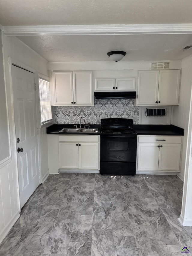 314 Arnold Blvd, Warner Robins, GA 31093 - kitchen with black electric range, dark countertops, under cabinet range hood, white cabinetry, and ornamental molding