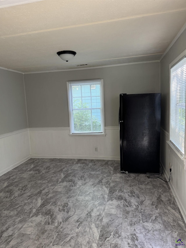 314 Arnold Blvd, Warner Robins, GA 31093 - spare room featuring a wainscoted wall, ornamental molding, and a decorative wall