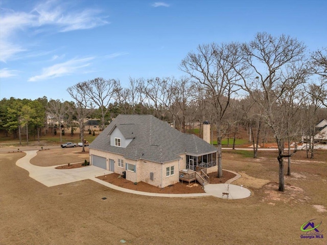 117 Pine Bough Trl, Perry, GA 31609 - view of side of property featuring a chimney, driveway, a garage, and view of wooded area