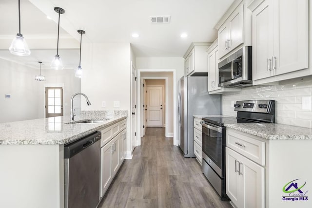 102 Sugar Creek Trl, Perry, GA 31069 - kitchen with appliances with stainless steel finishes, a peninsula, decorative backsplash, wood finished floors, and light stone counters