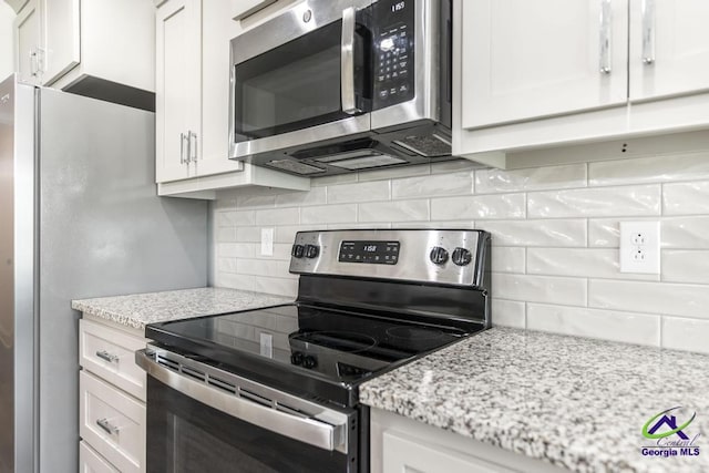 102 Sugar Creek Trl, Perry, GA 31069 - kitchen with appliances with stainless steel finishes, tasteful backsplash, white cabinetry, and light stone counters