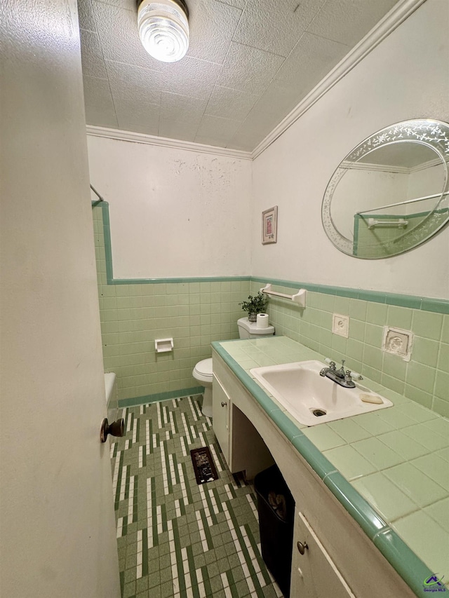 304 Mcwhorter St, Unadilla, GA 31091 - bathroom featuring vanity, tile patterned flooring, tile walls, a wainscoted wall, and a tub