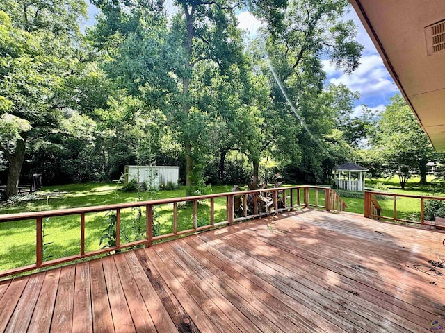 304 Mcwhorter St, Unadilla, GA 31091 - wooden terrace featuring a gazebo, a lawn, view of wooded area, and a storage unit