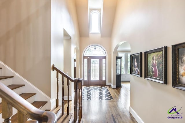 109 Black Oak Ct, Byron, GA 31008 - foyer featuring arched walkways, wood finished floors, a towering ceiling, and stairs