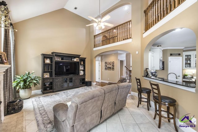 109 Black Oak Ct, Byron, GA 31008 - living room featuring ceiling fan, light tile patterned floors, high vaulted ceiling, arched walkways, and stairs
