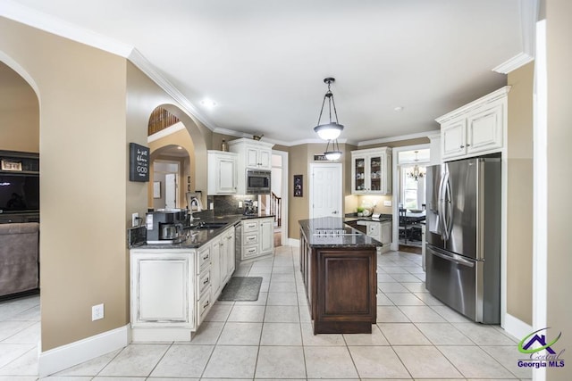 109 Black Oak Ct, Byron, GA 31008 - kitchen featuring stainless steel appliances, arched walkways, a center island, ornamental molding, and backsplash