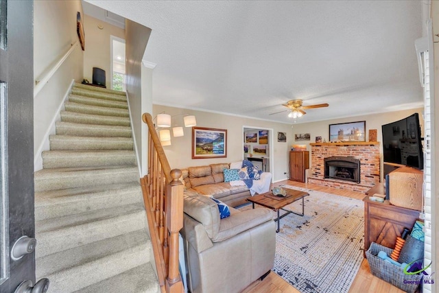 574 Shadow Moss Dr, Macon, GA 31204 - living area with ceiling fan, stairway, wood finished floors, a brick fireplace, and crown molding