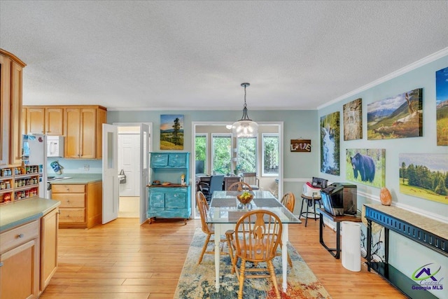 574 Shadow Moss Dr, Macon, GA 31204 - dining area with a textured ceiling, ornamental molding, light wood-style flooring, and a chandelier