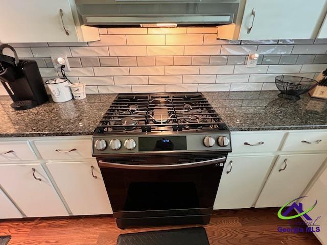 234 Briarcliff Rd, Warner Robins, GA 31088 - kitchen featuring range with gas stovetop, ventilation hood, dark wood-type flooring, and white cabinets
