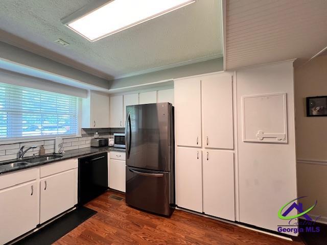 234 Briarcliff Rd, Warner Robins, GA 31088 - kitchen with black appliances, dark countertops, dark wood-type flooring, white cabinets, and decorative backsplash