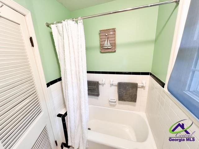 234 Briarcliff Rd, Warner Robins, GA 31088 - full bathroom featuring a tub to relax in, tile walls, wainscoting, and a shower with shower curtain
