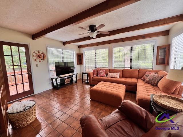 234 Briarcliff Rd, Warner Robins, GA 31088 - living room with a textured ceiling, beam ceiling, healthy amount of natural light, tile patterned flooring, and a ceiling fan