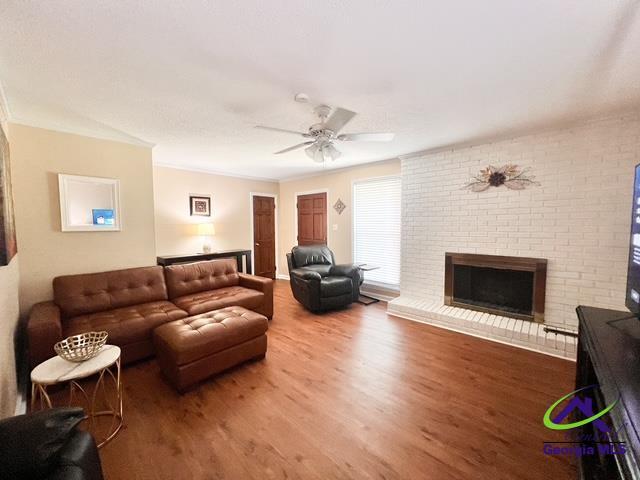 234 Briarcliff Rd, Warner Robins, GA 31088 - living area with wood finished floors, ceiling fan, and a brick fireplace