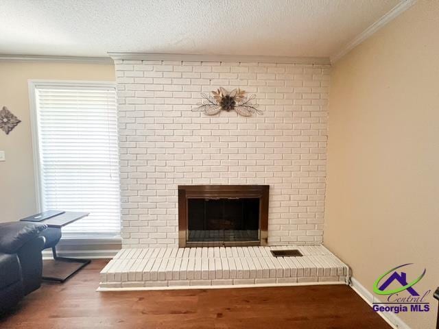 234 Briarcliff Rd, Warner Robins, GA 31088 - detailed view of ornamental molding, wood finished floors, a textured ceiling, and a brick fireplace