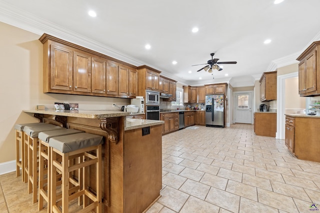 513 Litchfield, Macon, GA 31220 - kitchen with stainless steel appliances, a peninsula, brown cabinets, a ceiling fan, and ornamental molding