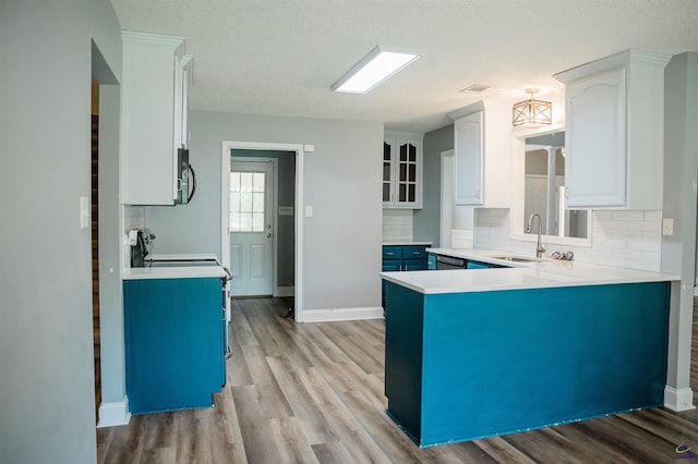 121 Spring Chase Cir, Kathleen, GA 31047 - kitchen featuring blue cabinetry, light wood-type flooring, decorative backsplash, and a textured ceiling