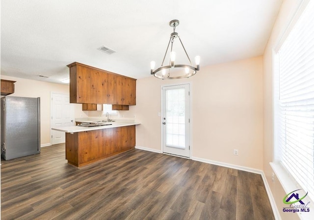 313 Strawbridge Ln, Bonaire, GA 31005 - kitchen with freestanding refrigerator, a peninsula, brown cabinets, dark wood-type flooring, and a chandelier