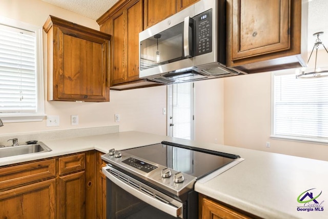 313 Strawbridge Ln, Bonaire, GA 31005 - kitchen featuring stainless steel appliances, brown cabinetry, and light countertops