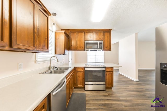 313 Strawbridge Ln, Bonaire, GA 31005 - kitchen with stainless steel appliances, a peninsula, dark wood-style floors, light countertops, and brown cabinetry