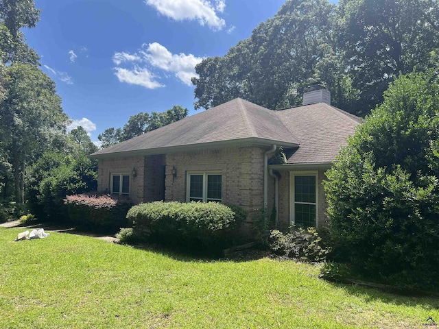 318 Pheasant Rdg, Warner Robins, GA 31088 - view of front of house with brick siding, a front yard, a chimney, and roof with shingles
