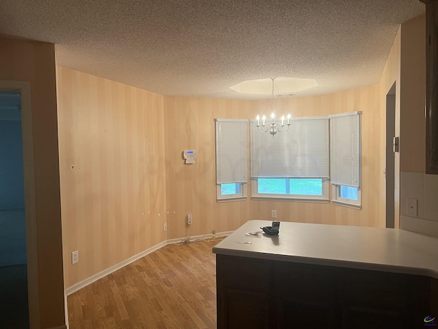 318 Pheasant Rdg, Warner Robins, GA 31088 - kitchen with a textured ceiling, a chandelier, light wood-style flooring, and a peninsula