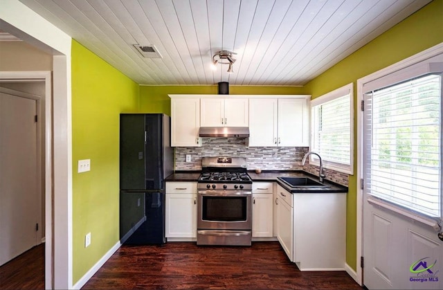 1714 Jean Ave, Albany, GA 31705 - kitchen with gas stove, under cabinet range hood, freestanding refrigerator, dark countertops, and decorative backsplash