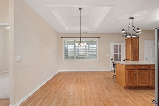 112 Finegand Pl, Warner Robins, GA 31088 - kitchen with a chandelier, a raised ceiling, light wood-style flooring, and brown cabinets