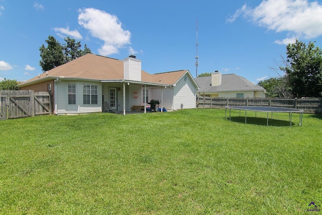 306 Bryson Way, Warner Robins, GA 31088 - back of property featuring a fenced backyard, a trampoline, and a chimney