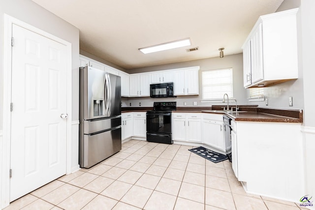 330 Hidden Creek Cir, Warner Robins, GA 31088 - kitchen with black appliances, dark countertops, light tile patterned flooring, and white cabinets