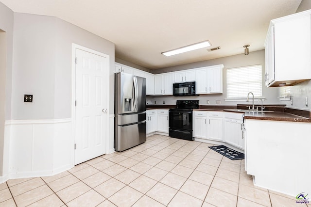 330 Hidden Creek Cir, Warner Robins, GA 31088 - kitchen featuring black appliances, dark countertops, white cabinets, and light tile patterned floors