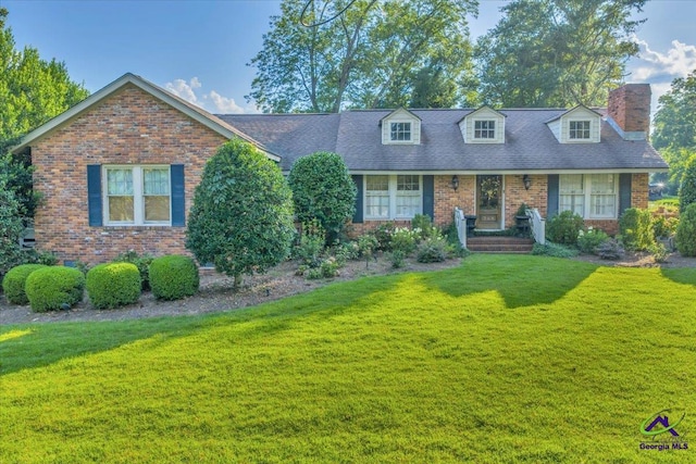 709 Evergreen St, Perry, GA 31069 - cape cod-style house with a chimney, a front yard, and brick siding