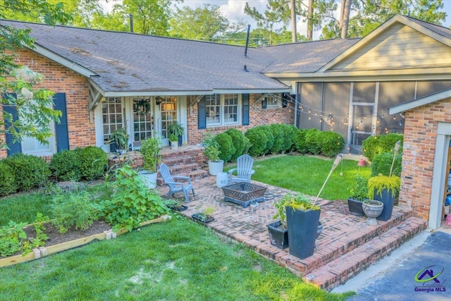 709 Evergreen St, Perry, GA 31069 - view of front facade with a fire pit, brick siding, a front lawn, and a patio area