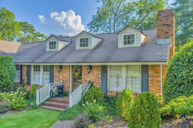 709 Evergreen St, Perry, GA 31069 - new england style home with a porch, brick siding, and a chimney