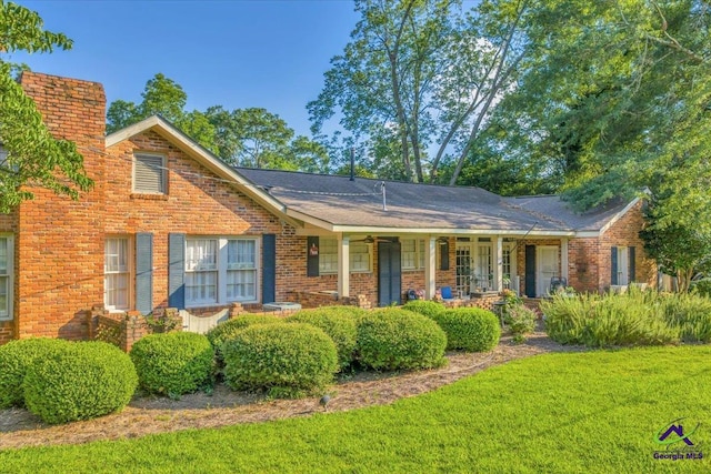 709 Evergreen St, Perry, GA 31069 - view of front of home with covered porch, a front yard, and brick siding