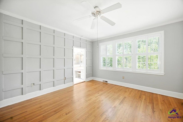458 Pierce Ave, Macon, GA 31204 - spare room with crown molding, a ceiling fan, light wood-style flooring, built in shelves, and a decorative wall
