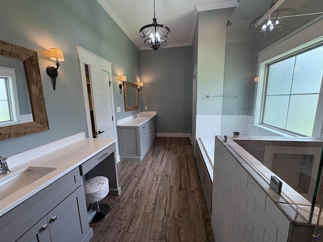 300 Stacy Ln, Warner Robins, GA 31088 - bathroom with ornamental molding, wood finished floors, a bath, two vanities, and a chandelier