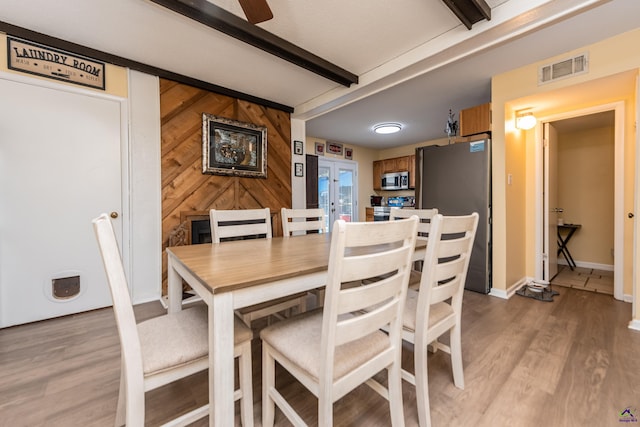113 Stoneridge Dr, Warner Robins, GA 31088 - dining space with beamed ceiling, light wood finished floors, a ceiling fan, and wood walls