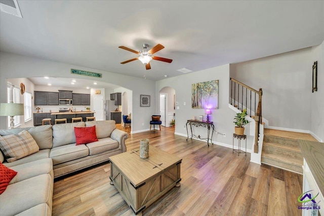 215TYNDALLWAY Tyndall Way, Perry, GA 31069 - living room with arched walkways, a ceiling fan, light wood-style floors, and stairway