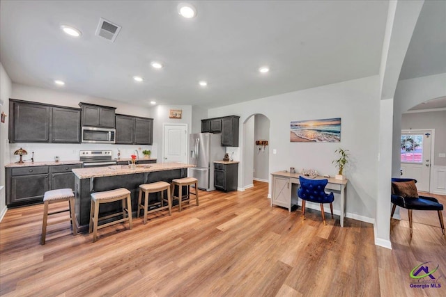 215TYNDALLWAY Tyndall Way, Perry, GA 31069 - kitchen with stainless steel appliances, arched walkways, a breakfast bar, light wood-style flooring, and recessed lighting