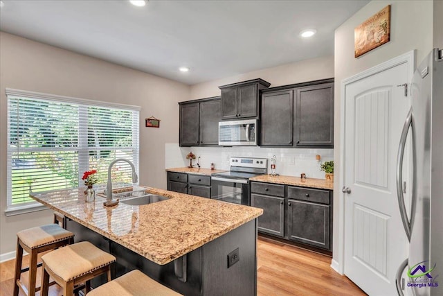 215TYNDALLWAY Tyndall Way, Perry, GA 31069 - kitchen with stainless steel appliances, healthy amount of natural light, a breakfast bar area, light stone countertops, and recessed lighting