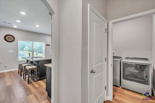 215TYNDALLWAY Tyndall Way, Perry, GA 31069 - washroom with washer and clothes dryer, arched walkways, light wood-style flooring, and recessed lighting