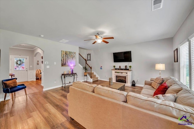 215TYNDALLWAY Tyndall Way, Perry, GA 31069 - living room with arched walkways, light wood finished floors, a ceiling fan, stairs, and a fireplace