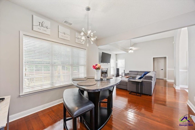 129 Sugarloaf Dr, Macon, GA 31204 - dining space with a chandelier, a fireplace, wood finished floors, and a textured ceiling