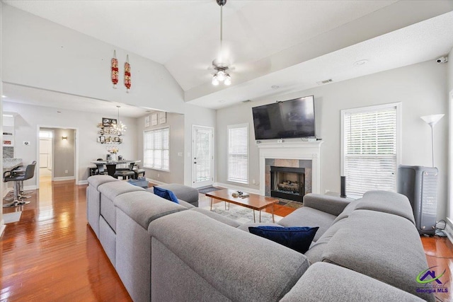 129 Sugarloaf Dr, Macon, GA 31204 - living room featuring light wood-type flooring, lofted ceiling, a tiled fireplace, and ceiling fan