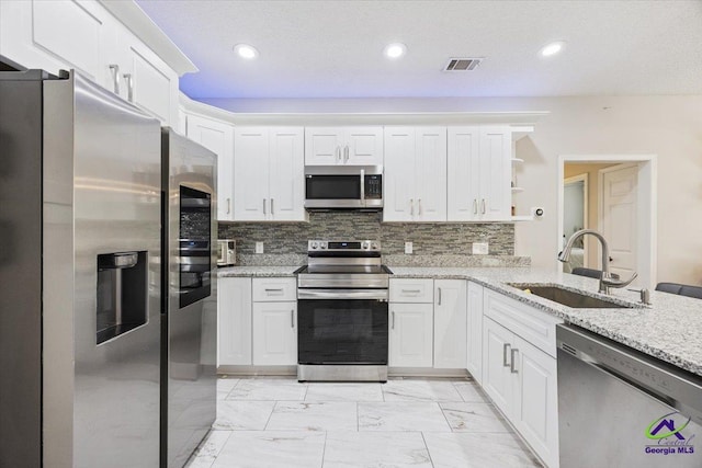 129 Sugarloaf Dr, Macon, GA 31204 - kitchen featuring stainless steel appliances, white cabinets, open shelves, light stone countertops, and recessed lighting
