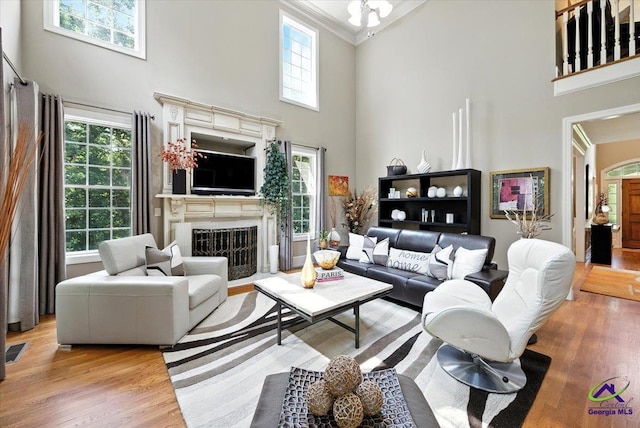 612 Remington Dr, Macon, GA 31210 - living area featuring a towering ceiling, a fireplace, crown molding, plenty of natural light, and light wood finished floors